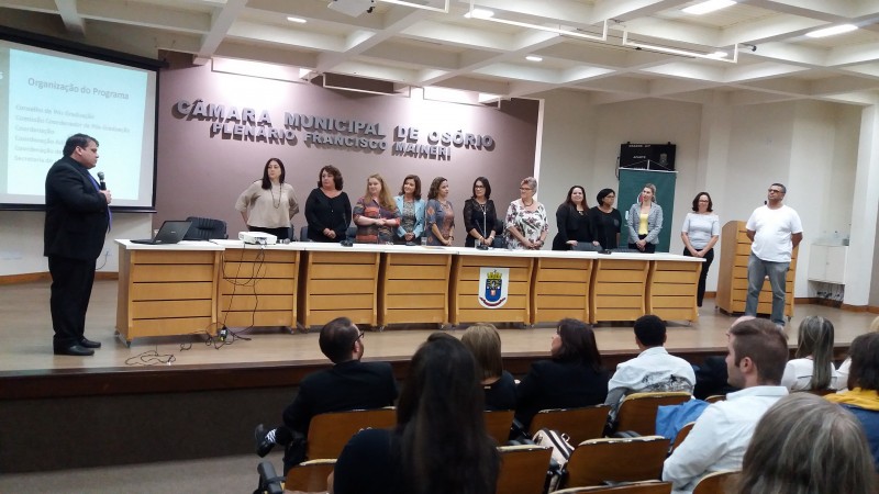 No palco, os professores do curso em pé.