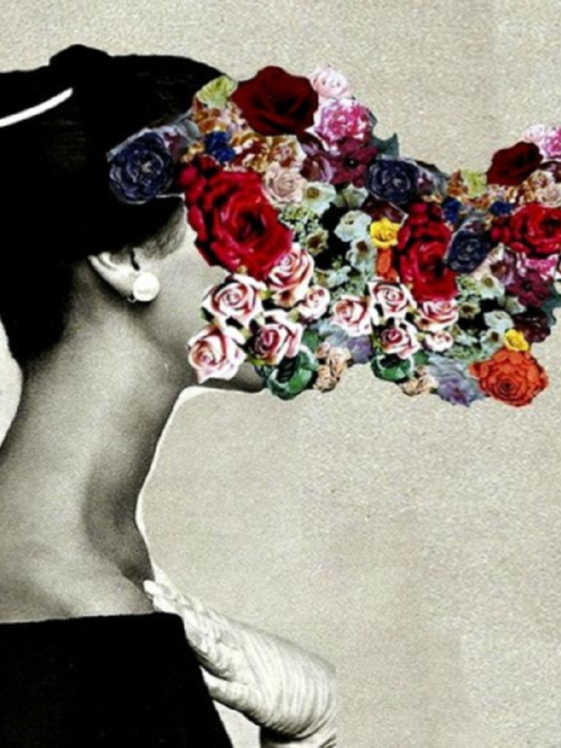 Uma mulher de perfil com a mão esquerda encostando no peito, usa luva branca e um arranjo na cabeça com os cabelos presos. Cobrindo o seu rosto, algumas rosas em diversas cores.