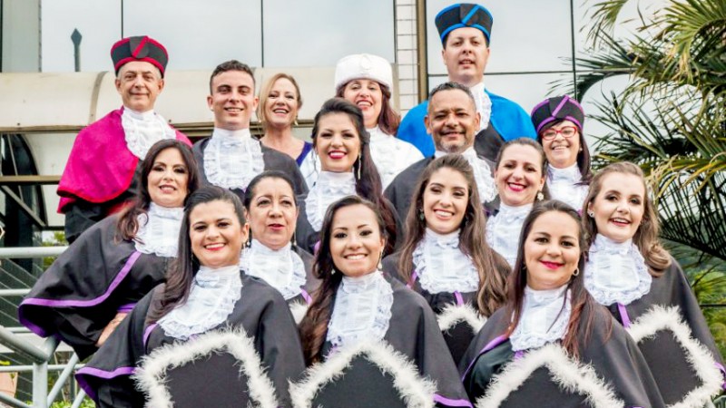 Quinze pessoas de toga, enfileiradas em uma escada, posam sorridentes.