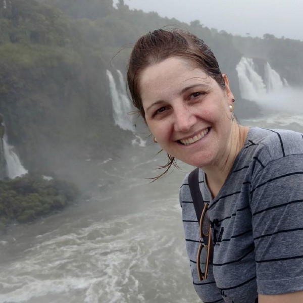 Mulher de pele clara, cabelos escuros presos atrás da cabeça.