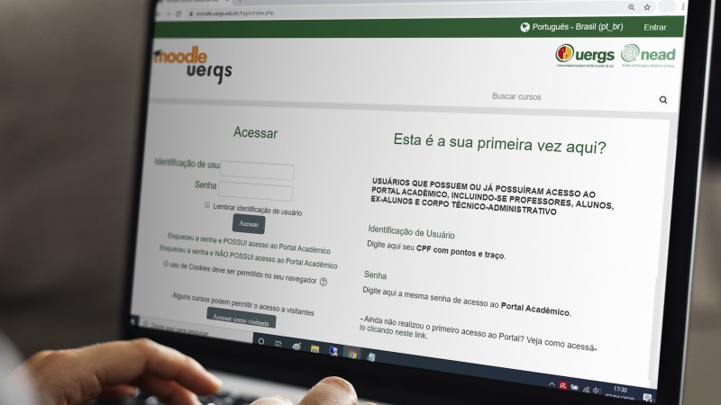 Foto colorida. Em destaque, a tela de um notebook com a imagem da página de acesso ao Moodle da Uergs.