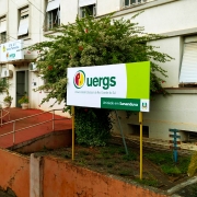 Foto colorida da fachada da unidade; prédio com muitas janelas e placa identidicando a unidade na frente.