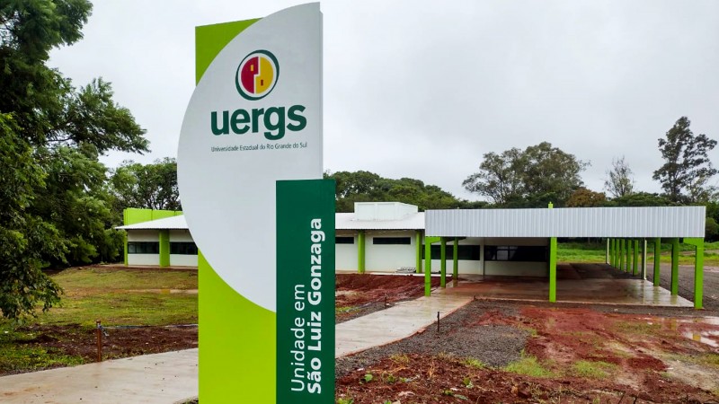 Totem com a identificação da unidade em destaque; ao fundo, prédio térreo da unidade.