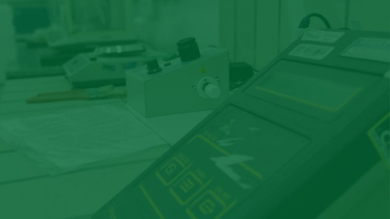 Foto com filtro verde de uma mesa com três equipamentos de laboratório.